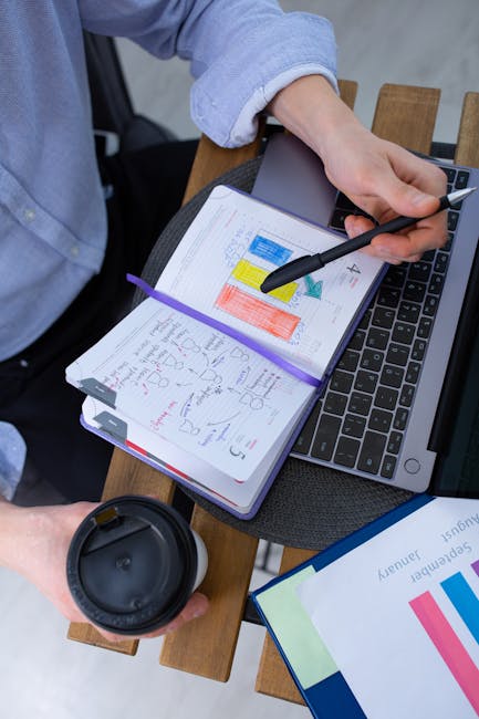 Cuaderno con anotaciones a mano junto a una computadora portátil
